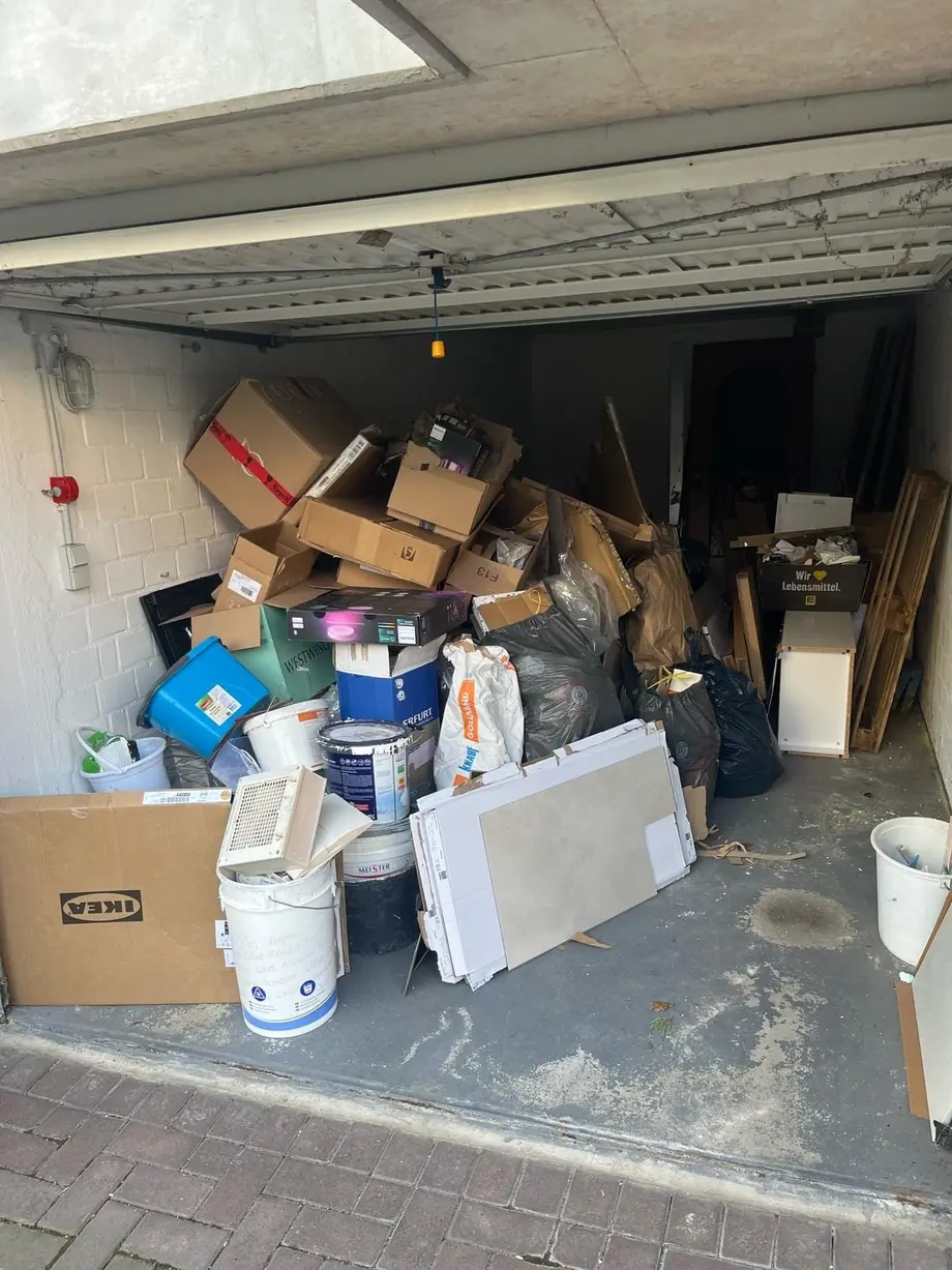 Volle Garage mit Möbeln und Kartons vor der Räumung