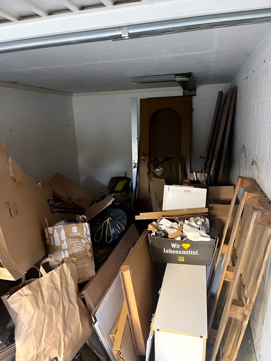 Volle Garage mit Möbeln und Kartons vor der Räumung
